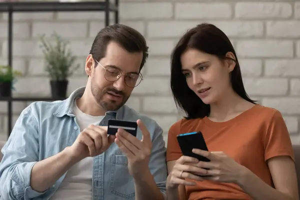 Millennial marido la enseñanza de la esposa para hacer el pago sin efectivo utilizando el teléfono — Foto de Stock