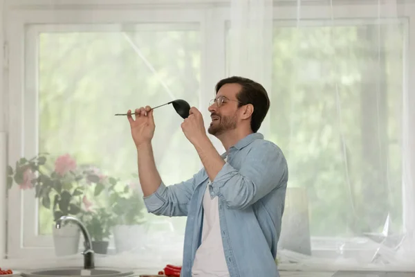 Joven alegre bailando y cantando canción favorita en la cocina — Foto de Stock