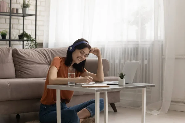 Jovem do sexo feminino estudando em piso aquecido por mesa com laptop — Fotografia de Stock