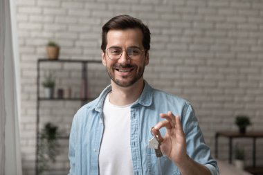 Satılık daire anahtarlarıyla poz veren arkadaş canlısı bir simsar.