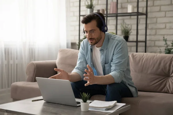 Young man teacher giving distant lesson in headset using pc — Stock Photo, Image