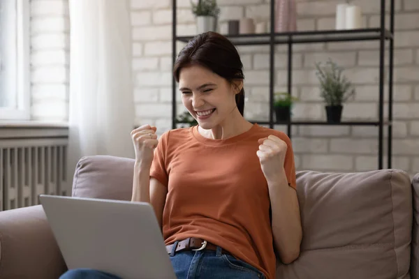 Excited millennial female reading good news from computer screen — Stock Photo, Image