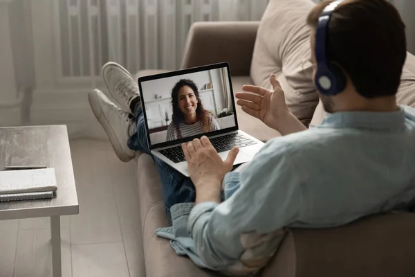 Calm millennial man relaxing on sofa chatting with wife online — Stock Photo, Image