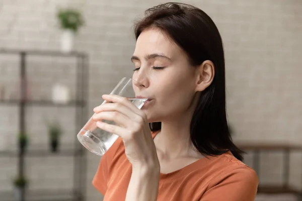 Hermosa hembra milenaria disfrutando bebiendo agua dulce pura en casa — Foto de Stock