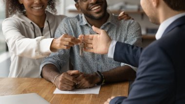 Emlakçı mutlu çiftlerin anahtarlarını verir.