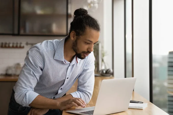 Афроамериканець працює на ноутбуці в офісі. — стокове фото