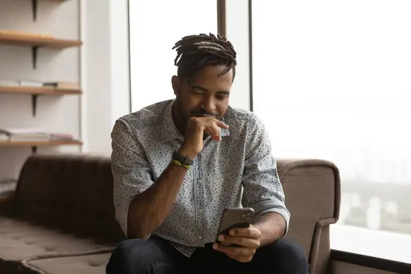 Africano homem americano usar smartphone relaxante em casa — Fotografia de Stock