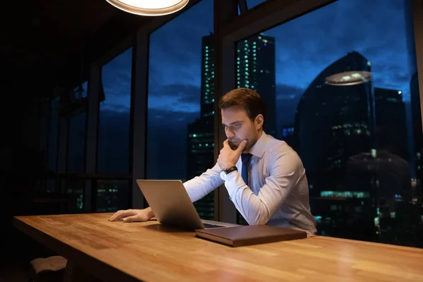 Lavoro dipendente maschile pensieroso in ufficio fino a tardi — Foto Stock