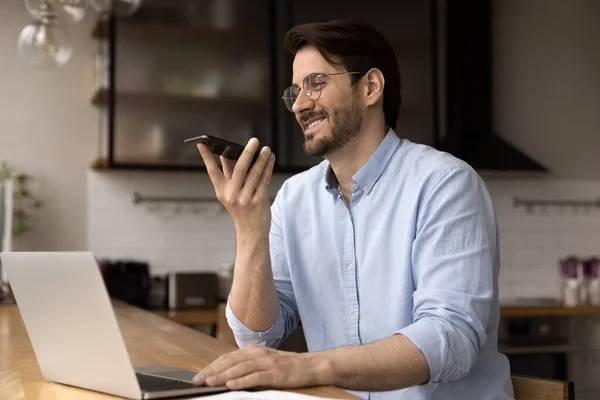 L'uomo sorridente registra il messaggio audio sullo smartphone — Foto Stock