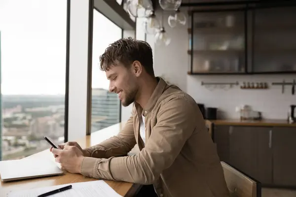 Sonriendo hombre caucásico utilizar el teléfono inteligente en la oficina —  Fotos de Stock