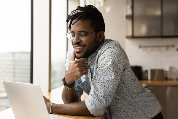 Sonriente biracial hombre trabajo en línea en el ordenador portátil —  Fotos de Stock