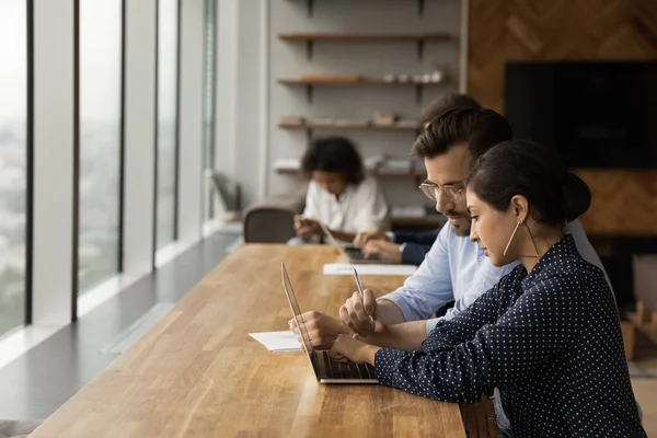 I colleghi diversi lavorano insieme su computer portatile in ufficio — Foto Stock