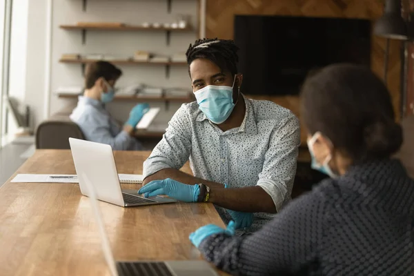 Compañeros multirraciales en equipo de protección médica cooperan en la oficina — Foto de Stock