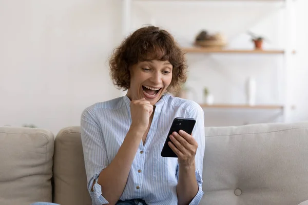 Excited female shopper holding phone getting email offering unbelievable sales — Stock Photo, Image