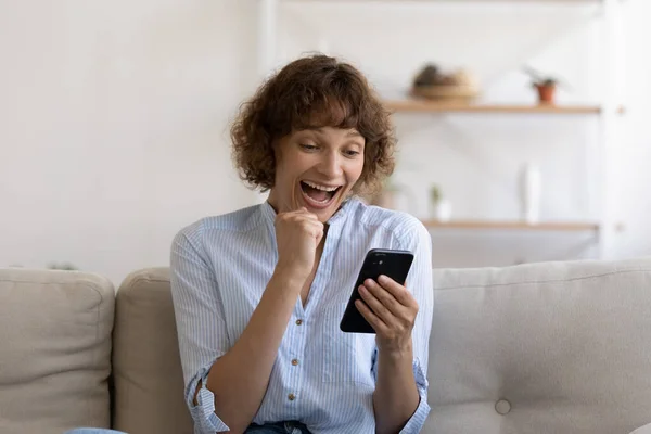 Opgewonden vrouwelijke shopper holding telefoon krijgen e-mail met een ongelooflijke verkoop — Stockfoto