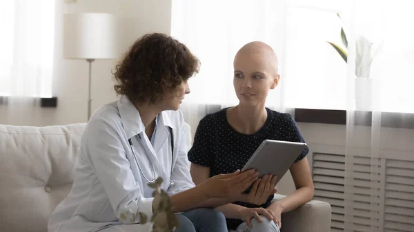 Physician explain treatment to female sick with cancer using tablet