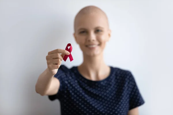 Jovem senhora com oncologia olhar para câmera segurar fita escarlate — Fotografia de Stock