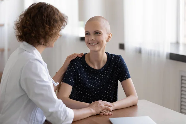 Hopeful young sick woman sit at desk listen to doctor — Stock Photo, Image