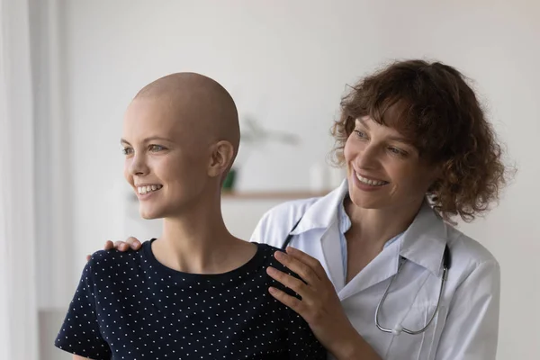 Donna ottimista medico abbraccio sorridente paziente cancro femminile da dietro — Foto Stock