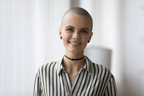 Миллениальный лысый мужчина женского пола, смотрящий в камеру