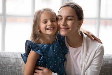 Mutlu anne ve küçük kız yanaklarına dokunuyor.