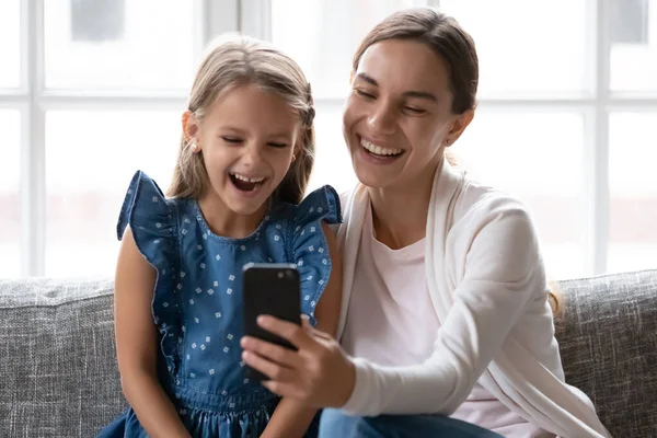 Close up madre felice con la piccola figlia utilizzando il telefono insieme — Foto Stock