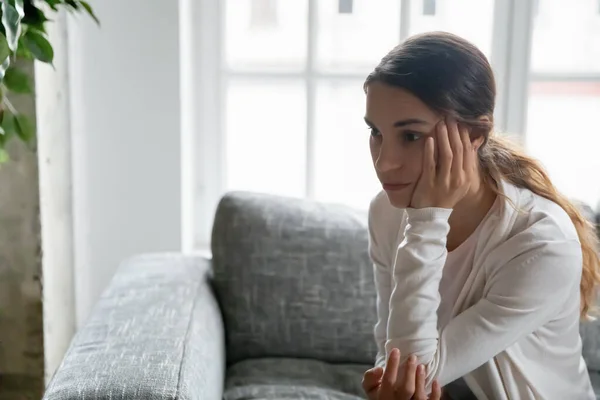 Nahaufnahme verärgert nachdenkliche junge Frau, die zur Seite schaut — Stockfoto