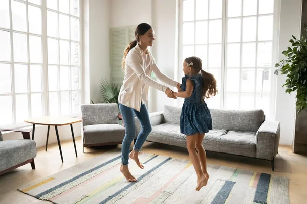 Boldog fiatal anya és kislánya táncol, élvezi a szabadidős tevékenységet — Stock Fotó