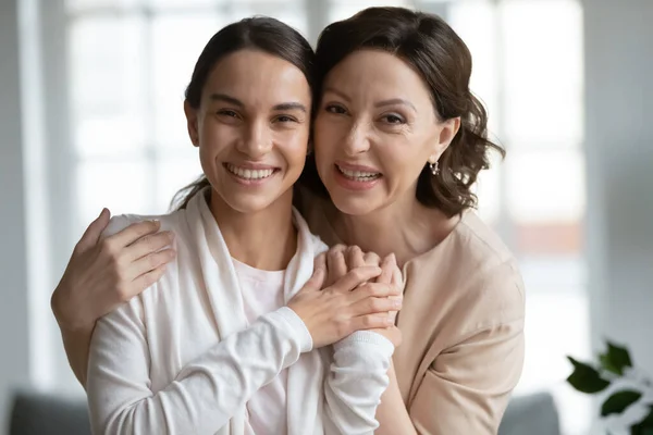 Cabeça tiro retrato sorrindo meia idade mãe abraçando adulto filha — Fotografia de Stock