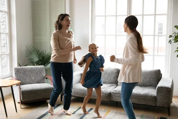 Excited little girl with grandmother and mother dancing together — Stock Photo, Image