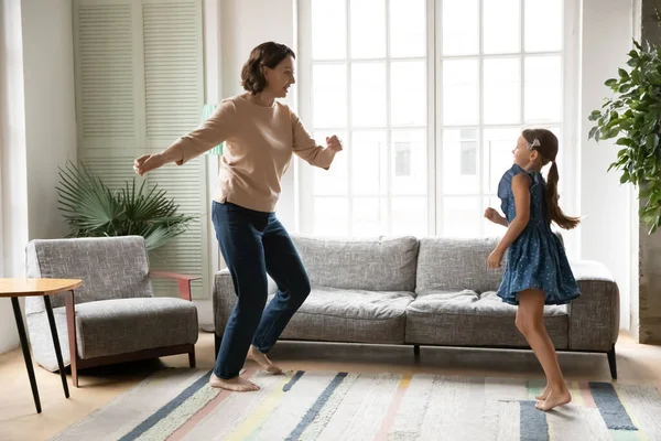 Overblij volwassen grootmoeder en kleine kleindochter dansen thuis — Stockfoto