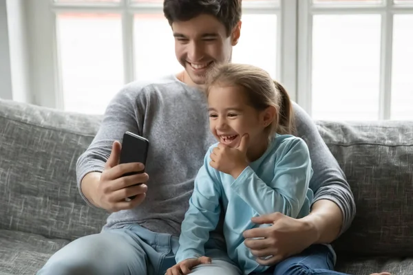 Cerca de padre e hija divirtiéndose con el teléfono —  Fotos de Stock