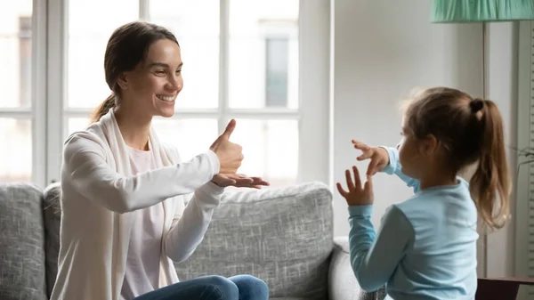 Крупним планом мати і маленька глуха дочка розмовляють жестовою мовою — стокове фото
