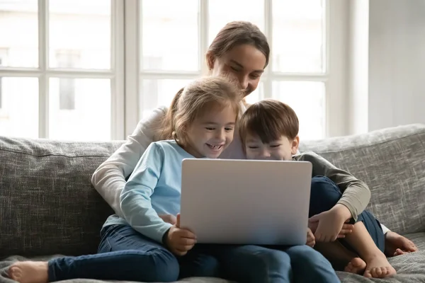 Fechar a mãe e dois filhos se divertindo com laptop — Fotografia de Stock