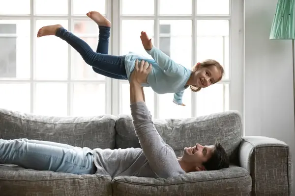 Grappig portret vader houden glimlachende kleine dochter doen alsof vliegen — Stockfoto