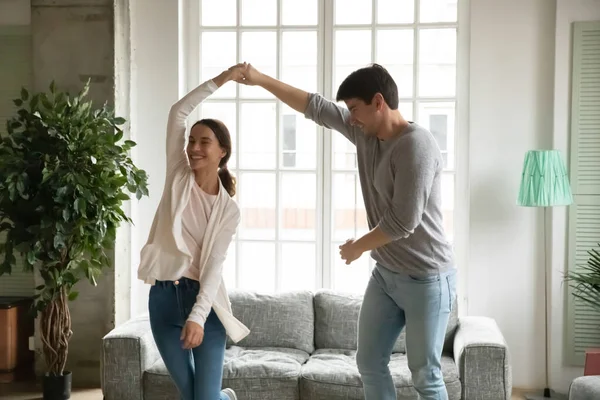 Gelukkige jonge vrouw en man hand in hand, dansen samen — Stockfoto