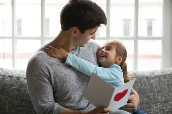 Крупным планом любящая маленькая дочь поздравляет отца с открыткой — стоковое фото