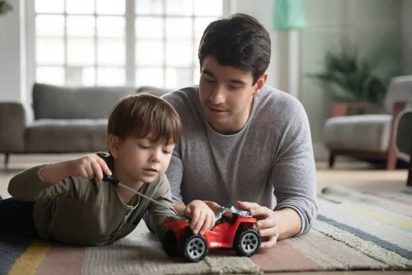 De cerca padre e hijo pequeño jugando con coche de juguete —  Fotos de Stock