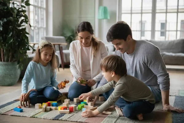 Közelkép boldog szülők és két gyerek játszik játékok — Stock Fotó
