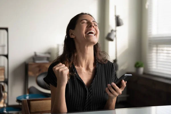 Donna eccitata trionfo vincere la lotteria su smartphone — Foto Stock