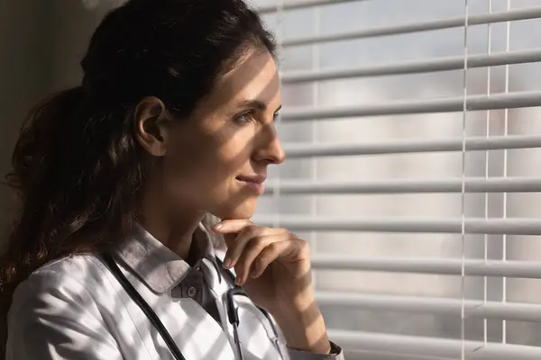 Happy female doctor look in distance dreaming — Stock Photo, Image