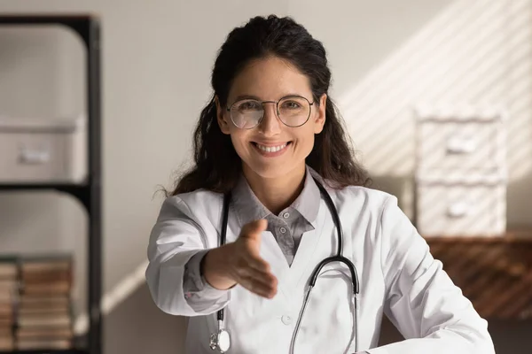 Ritratto di donna sorridente medico allungare la mano saluto — Foto Stock