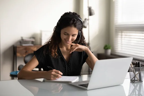 Gelukkig vrouw in koptelefoon studie online op laptop — Stockfoto