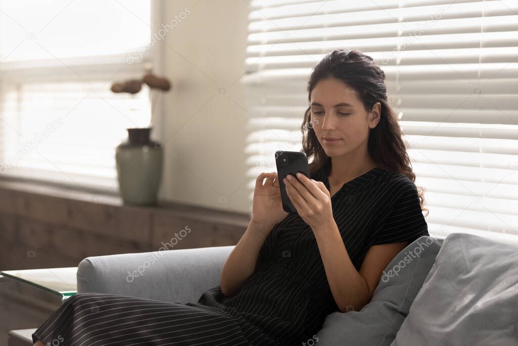 Woman relax on sofa using smartphone texting