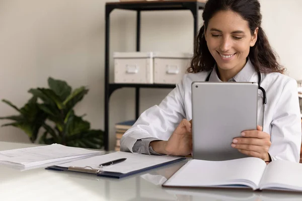 Glimlachende vrouwelijke arts gebruik tablet gadget in kliniek — Stockfoto