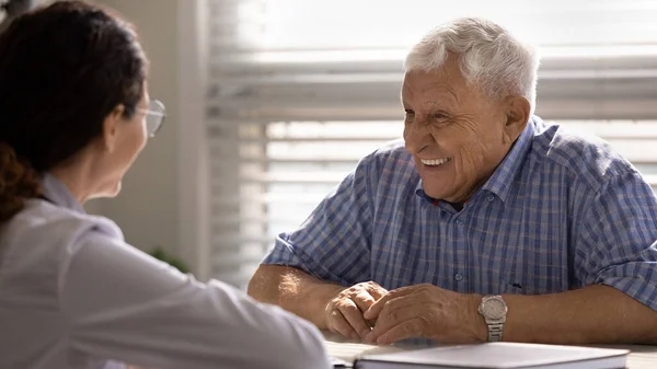 Баннерный вид улыбающегося пожилого пациента на консультации в больнице — стоковое фото