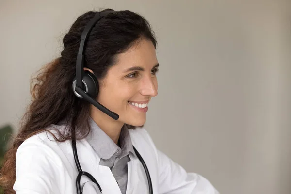 Close up of female doctor in headphones consult online