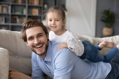 Küçük kızıyla rahatlayan mutlu bir babanın portresi.