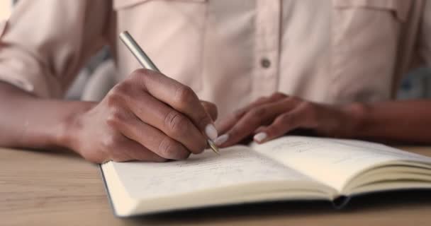 Afrykanka trzyma długopis pisze notatki w pamiętniku, widok z bliska — Wideo stockowe