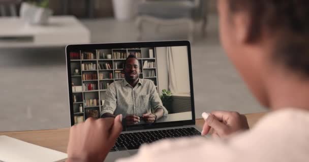 Mulher africana e homem negociando através de aplicativo de videocall no laptop — Vídeo de Stock